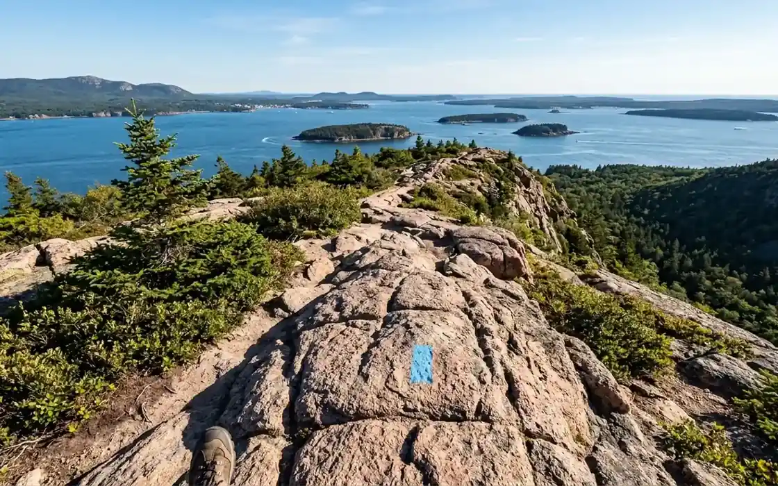 A blue trail blaze on open granite above Frenchman Bay on an Acadia hiking trail A blue trail blaze on open granite above Frenchman Bay on an Acadia hiking trail