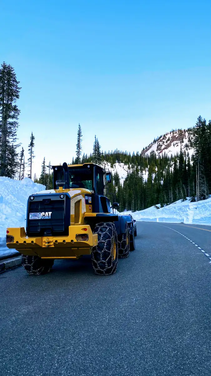 A wheel loader clearing deep snow from the Paradise road in Mount Rainier National Park in April A wheel loader clearing deep snow from the Paradise road in Mount Rainier National Park in April