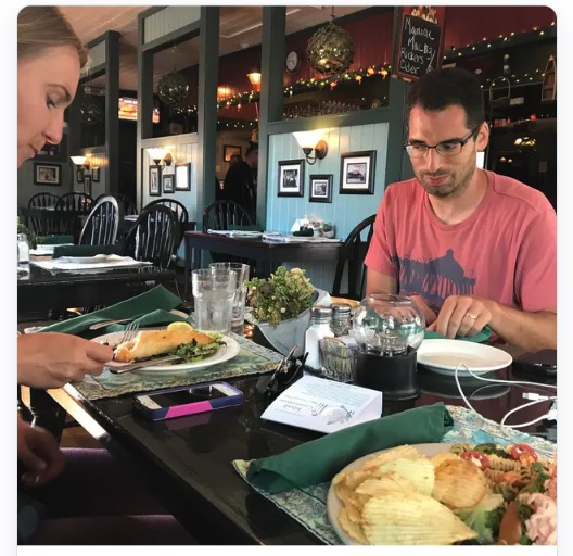 Two people eating dinner at a table in a Bar Harbor restaurant, Mount Desert Island, Maine